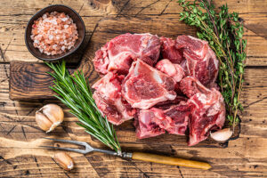 Raw,Beef,Meat,Diced,For,Stew,With,Bone.,Wooden,Background. 0