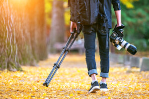 Professional,Photographer,With,Camera,And,Tripod,In,Autumn. 0